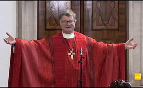 Bischof Scheuer verdeutlicht, wie wir mit unserem Körper ein Kreuz bilden können, wenn wir die Arme ausbreiten.